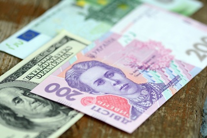 dollars euro and hryvnia banknotes on wooden background
